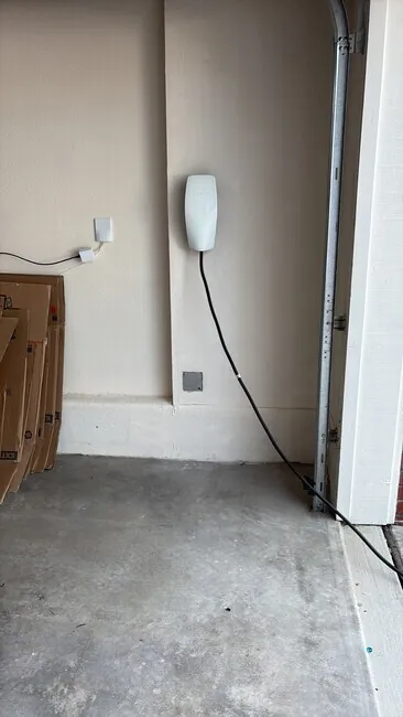 Wall-mounted EV charger beside a garage entry