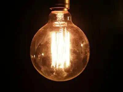 Bare light bulb glowing in a dark room