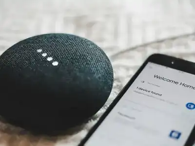 Smart speaker next to a phone running its app